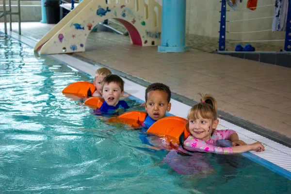 Children in group swimming lesson with armbands at M Swim, Staffordshire